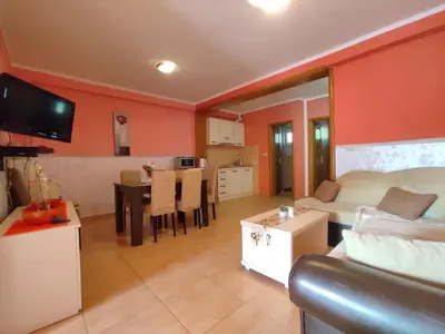 a living room with a couch and a dining room at Apartmani Tomić 4* in Rafailovici