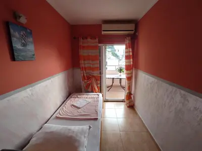 a small room with a bed in the corner at Apartmani Tomić 4* in Rafailovici