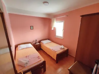 a small room with two beds and a window at Apartmani Tomić 4* in Rafailovici
