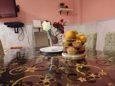 a table with a bowl of fruit and a vase of flowers at Apartmani Tomić 4* in Rafailovici