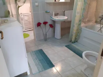 a bathroom with a toilet and a sink and a tub at Prima House in Podgorica