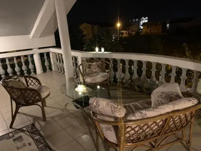 a patio with chairs and a glass table on a balcony at Prima House in Podgorica