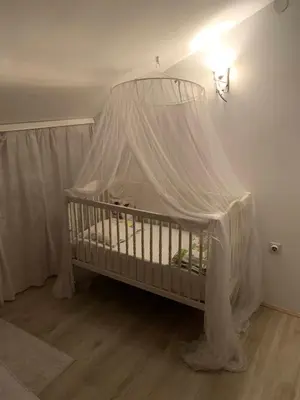 a crib with a canopy in a room at Prima House in Podgorica
