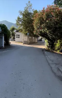 an empty street with a fence and a house at Apartman Luka Budva in Budva
