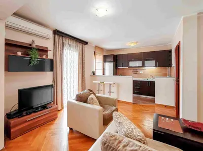 a living room with a couch and a flat screen tv at Sunny three-bedroom apartment in Budva in Budva