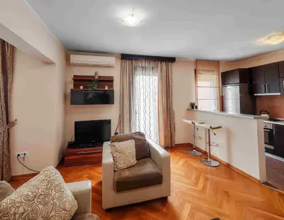a living room with a couch and a chair at Sunny three-bedroom apartment in Budva in Budva