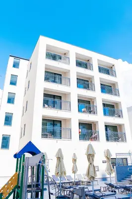 a hotel with tables and chairs in front of a building at Sunraf Luxe Apartments in Budva