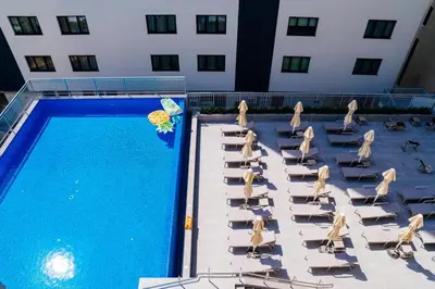 a group of lounge chairs and a swimming pool at Sunraf Luxe Apartments in Budva
