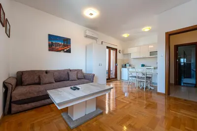 a living room with a couch and a table at Cozy studio with terrace in Budva
