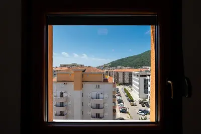 a window with a view of a parking lot at Cozy studio with terrace in Budva