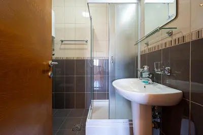 a bathroom with a sink and a shower with a mirror at Cozy studio with terrace in Budva