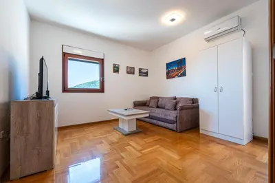 a living room with a couch and a table at Cozy studio with terrace in Budva