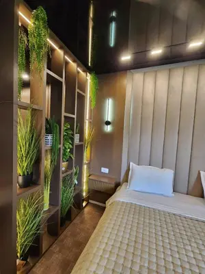 a bedroom with a bed with plants on the wall at Harmony Apartments in Podgorica