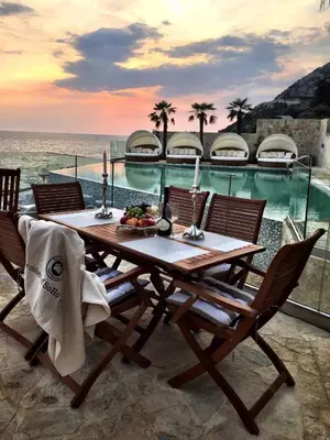 a wooden table with chairs next to a swimming pool at Apartment Your Home in Dobra Voda