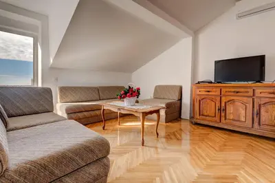a living room with a couch and a table and a tv at Villa Savovic in Petrovac na Moru