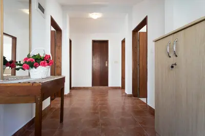 a hallway with a sink and a counter with flowers on it at Villa Savovic in Petrovac na Moru