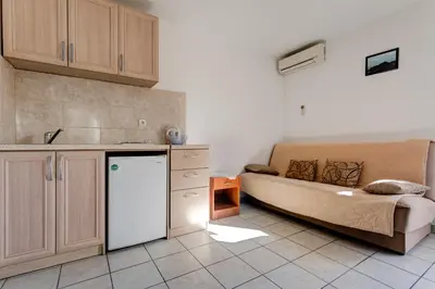 a kitchen with a couch and a refrigerator in a room at Villa Savovic in Petrovac na Moru