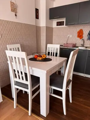 a kitchen table with chairs and a bowl of fruit on it at Flower and Love Flat Next to centar of podgorica in Podgorica
