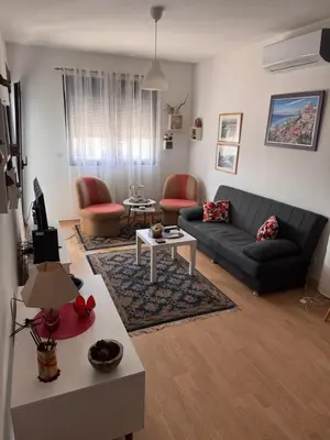 a living room with a black couch and red chairs at Flower and Love Flat Next to centar of podgorica in Podgorica