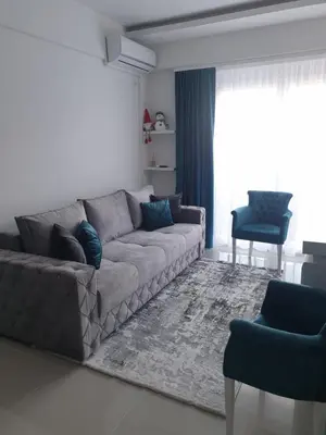 a living room with a gray couch and blue chairs at LUX Apartment - Central Place Bar in Bar