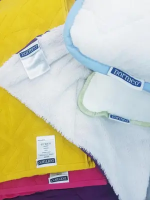 a pile of white blankets with labels on them at LUX Apartment - Central Place Bar in Bar