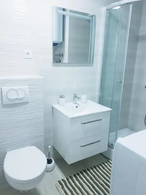 a white bathroom with a toilet and a sink at LUX Apartment - Central Place Bar in Bar