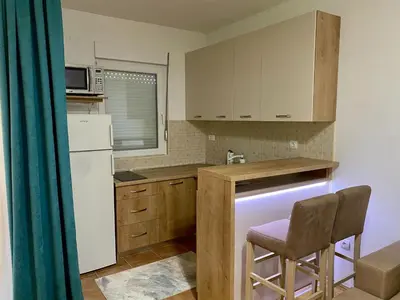 a small kitchen with a white refrigerator and a chair at RIO 1 in Podgorica