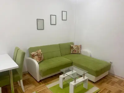 a living room with a green couch and a table at RIO 2 in Podgorica
