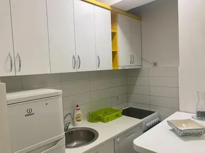 a kitchen with white cabinets and a sink at RIO 2 in Podgorica