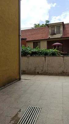 a building with a concrete wall and a house at Martha`s place Drač in Podgorica