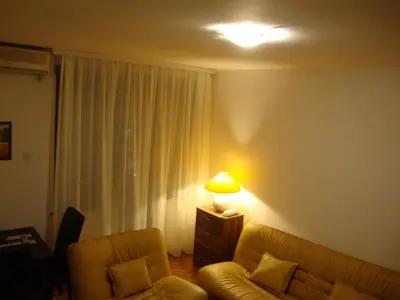 a living room with a couch and a lamp at Centre Point Apartment in Podgorica