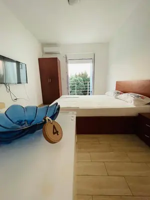 a bedroom with a large bed with a sign on it at Apart Hotel White Pearl in Bar