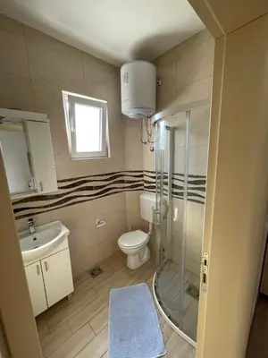 a bathroom with a shower and a toilet and a sink at Apart Hotel White Pearl in Bar