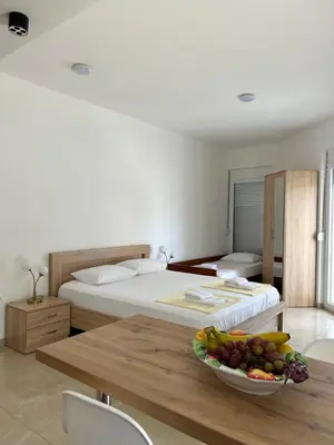 a bedroom with a bed and a bowl of fruit on a table at Apart Hotel White Pearl in Bar