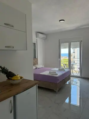 a bedroom with a purple bed in a room at Apart Hotel White Pearl in Bar