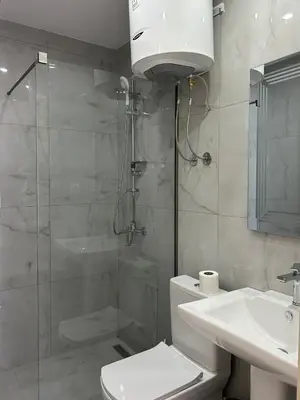 a bathroom with a shower and a toilet and a sink at Apart Hotel White Pearl in Bar