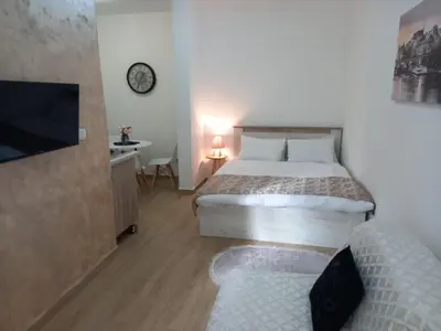 a bedroom with a bed and a tv and a couch at CASA APARTMENTS, one-bedroom apartment in Budva