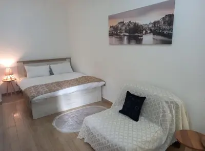 a small bedroom with a bed and a chair at CASA APARTMENTS, one-bedroom apartment in Budva