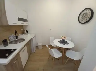 a kitchen with a table and a clock on the wall at CASA APARTMENTS, one-bedroom apartment in Budva