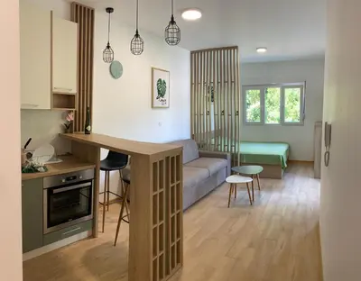 a kitchen and living room with a couch and a table at Cozy apartment in The Old Bakery Residences in Budva