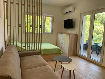 a living room with a couch and a bed at Cozy apartment in The Old Bakery Residences in Budva