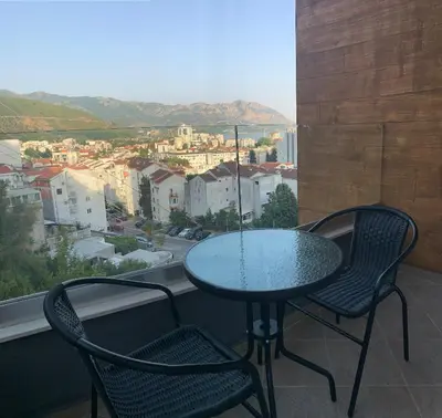 a table and two chairs on a balcony with a view at Cozy apartment in The Old Bakery Residences in Budva