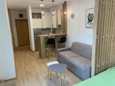 a living room with a couch and a kitchen at Cozy apartment in The Old Bakery Residences in Budva