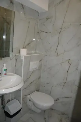 a white bathroom with a toilet and a sink at Villa Stanivukovic in Budva