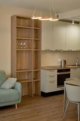 a kitchen with white cabinets and a table and a couch at BigMontenegro Belveder in Becici