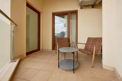 a balcony with a table and chairs and a window at BigMontenegro Belveder in Becici