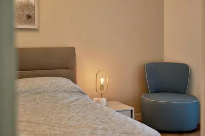 a bedroom with a bed and a blue chair at BigMontenegro Belveder in Becici
