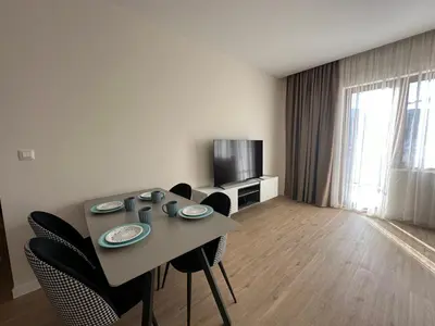 a living room with a table and chairs and a television at BigMontenegro Belveder in Becici