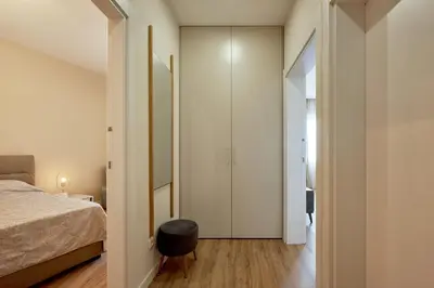 a bedroom with a bed and a stool next to a door at BigMontenegro Belveder in Becici