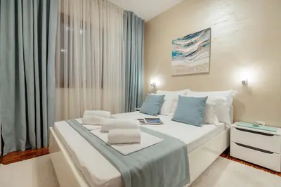 a bedroom with two beds with blue pillows at Apartments Dabinovic in Kotor